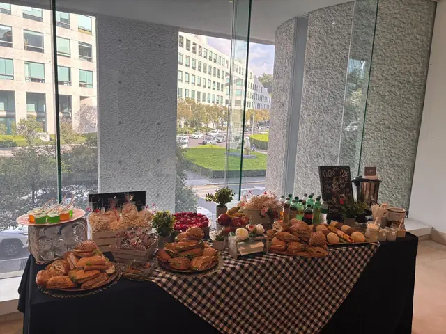 Coffee break con pan, bocadillos y bebidas para un curso en la Ciudad de México, junto a un ventanal