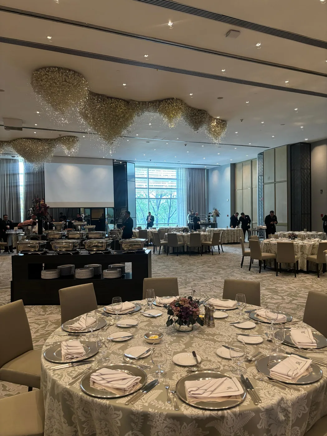 Salón de evento montado con mesas redondas y mantelería